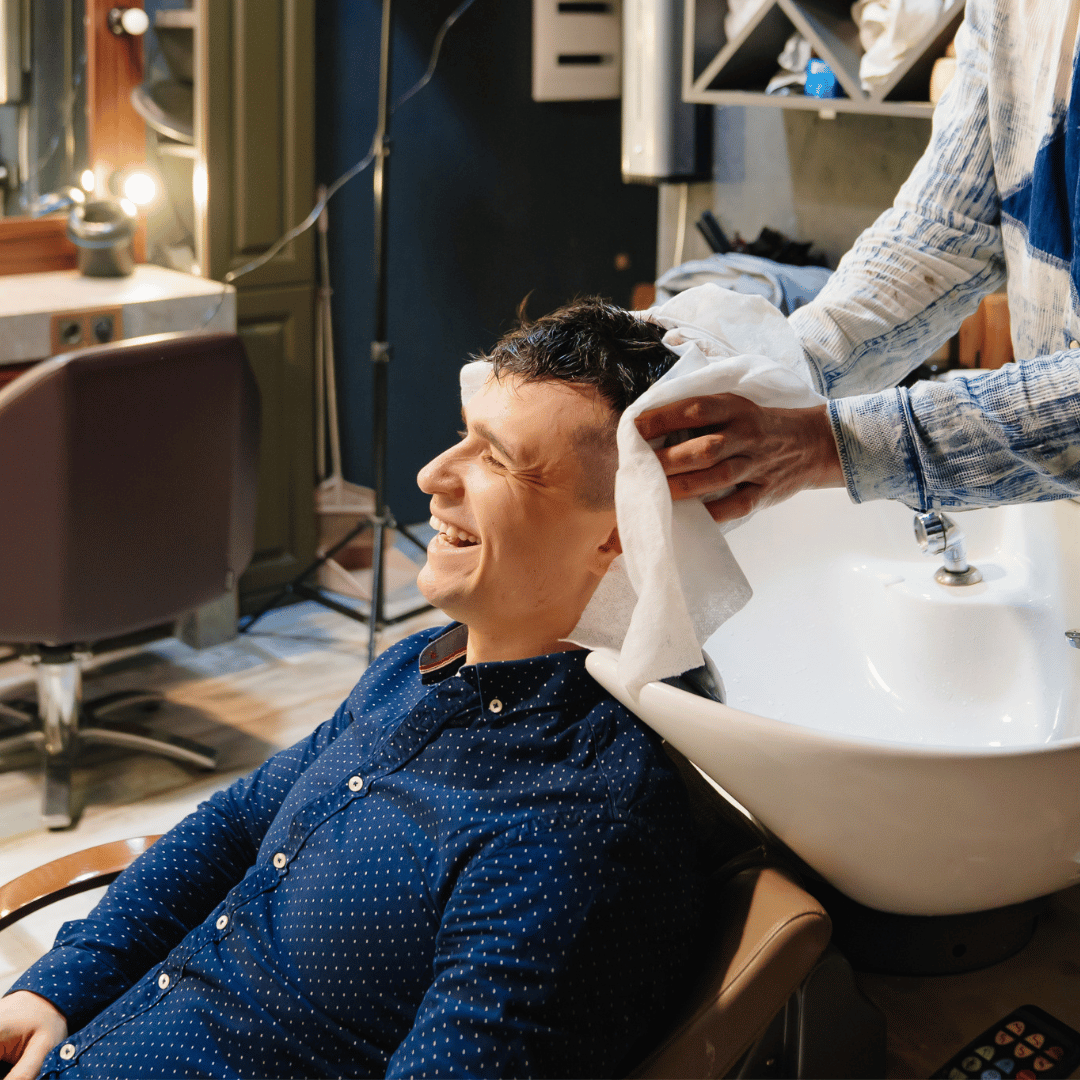 Barbero secando el cabello de un cliente con toalla desechable SpunLace en Gran Canaria, solución higiénica y práctica para barberías.