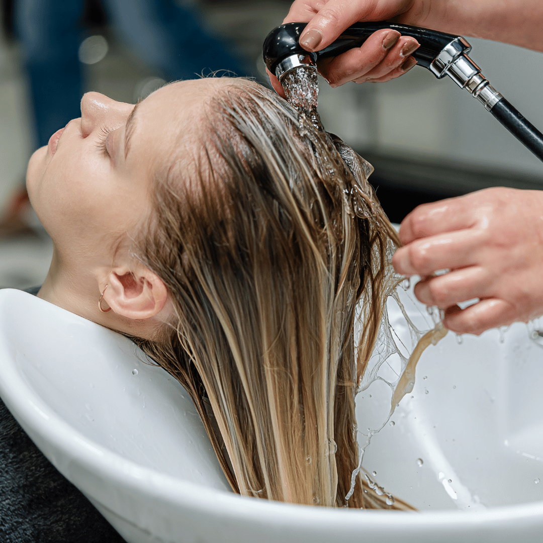 Cliente recibiendo un lavado de cabello con protección de toalla desechable SpunLace de 40x80 cm en salón de peluquería en Canarias.