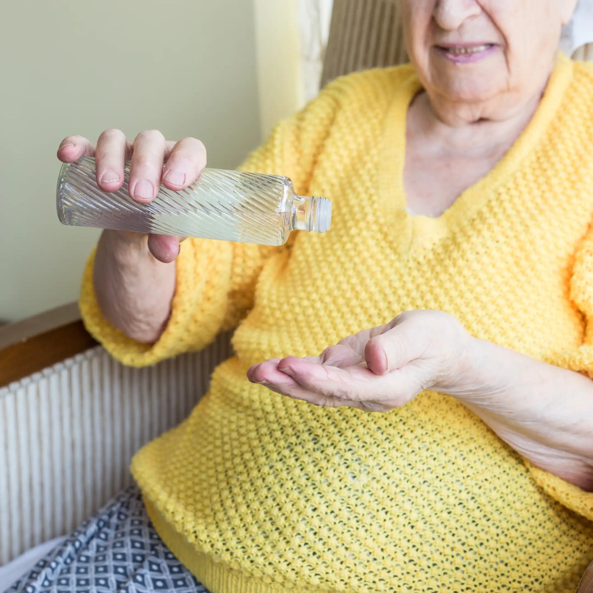 Señora mayor aplicando EAU de Colonia Fresca S’Nonas en las manos antes de extenderla sobre el cuerpo en Gran Canaria