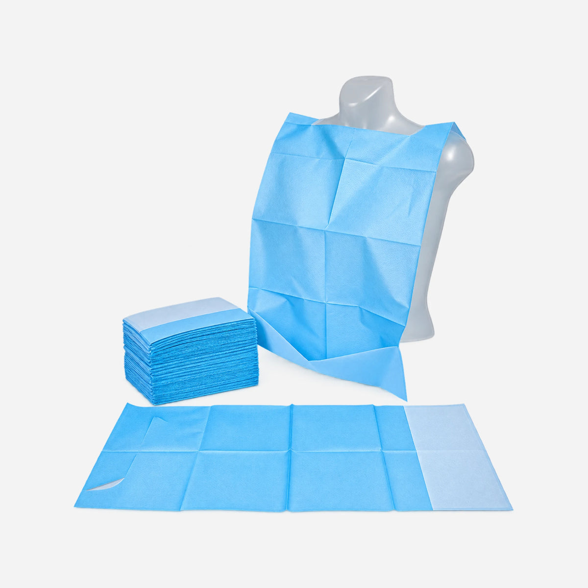 Babero de papel con bolsillo para adultos colocado sobre un maniquí, junto a varias unidades apiladas y un babero extendido.