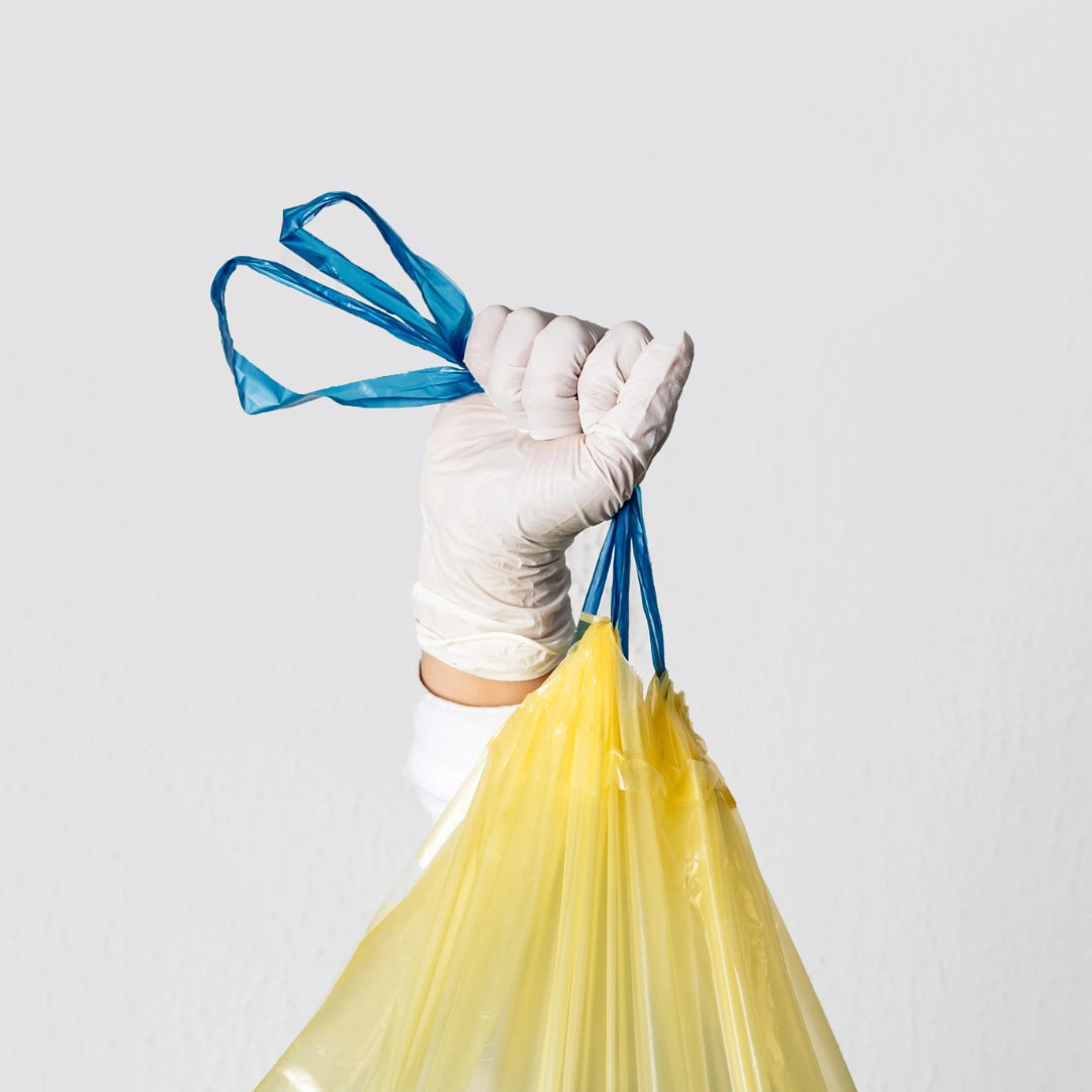 Detalle de una persona sujetando una bolsa de basura por las asas de autocierre en Gran Canaria.