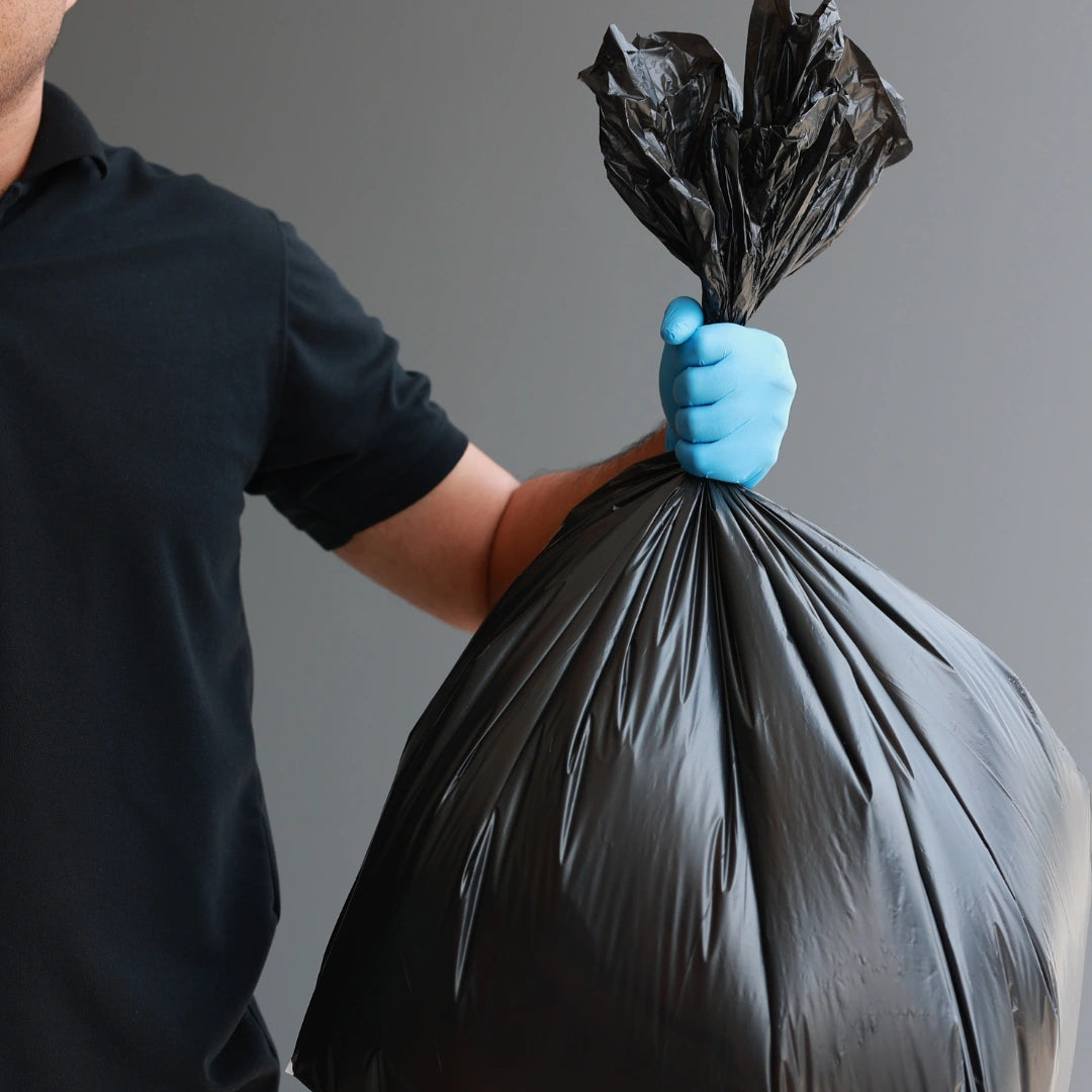 Persona sujetando por el extremo superior una bolsa de basura sin autocierre en Gran Canaria.