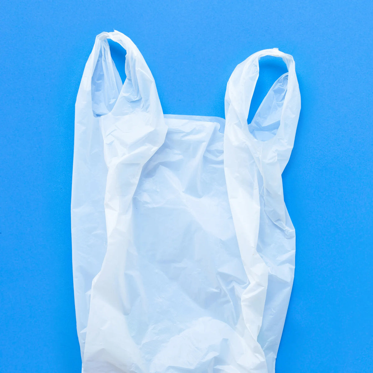Bolsa camisa blanca con asas para transportar productos de comercios en Gran Canaria.