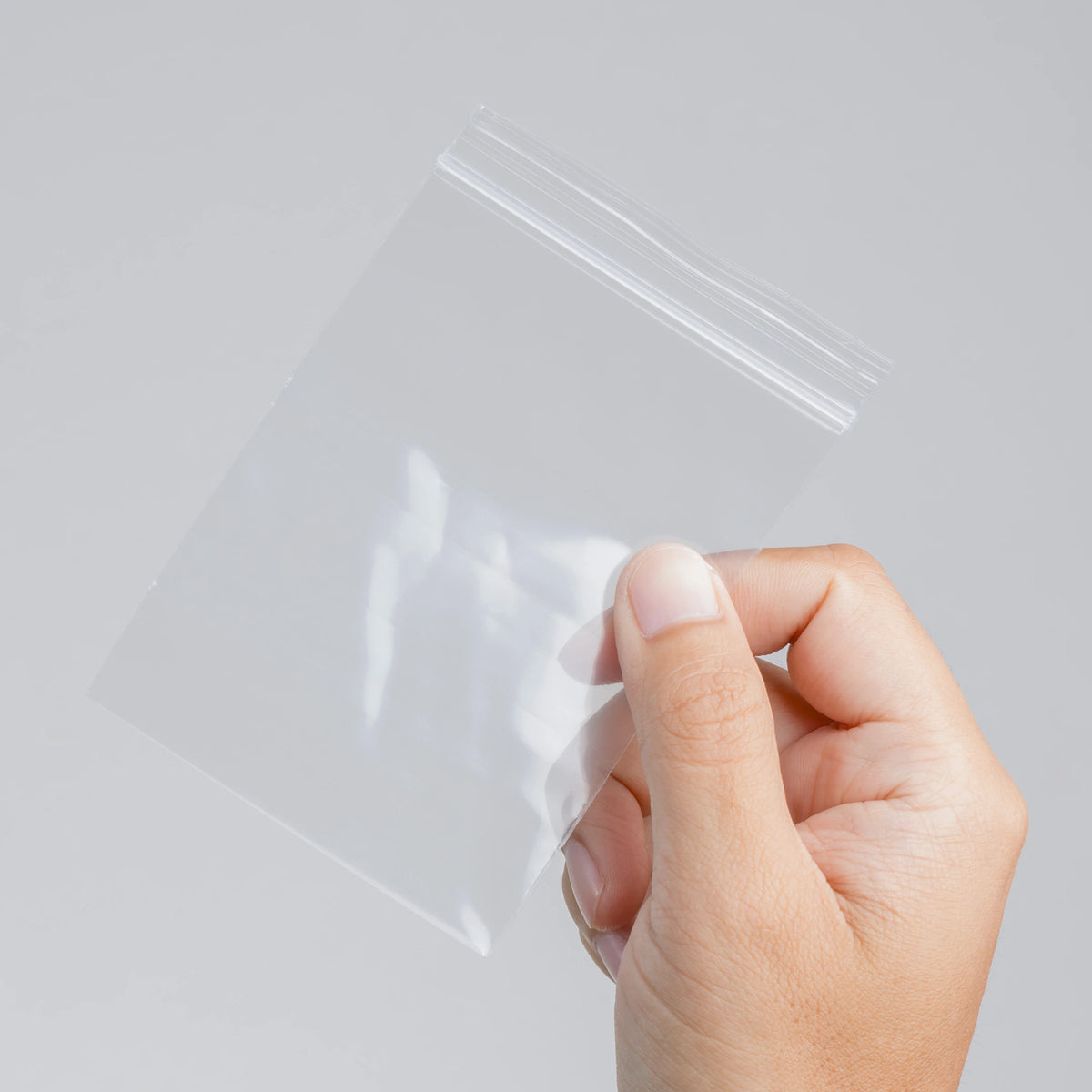 Persona sujetando una bolsa transparente con cierre ZIP para almacenamiento y organización en Gran Canaria.
