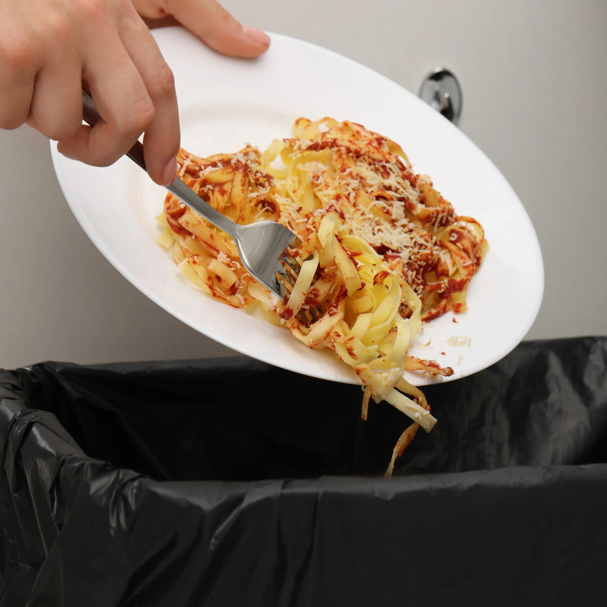 Persona depositando restos de comida en una bolsa negra para residuos en Gran Canaria.