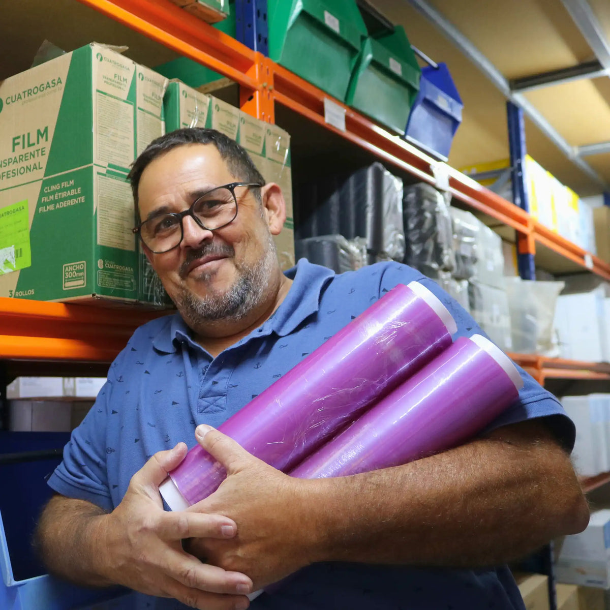 Miembro del equipo de DMP sujetando film profesional para hostelería en el almacén de Gran Canaria.