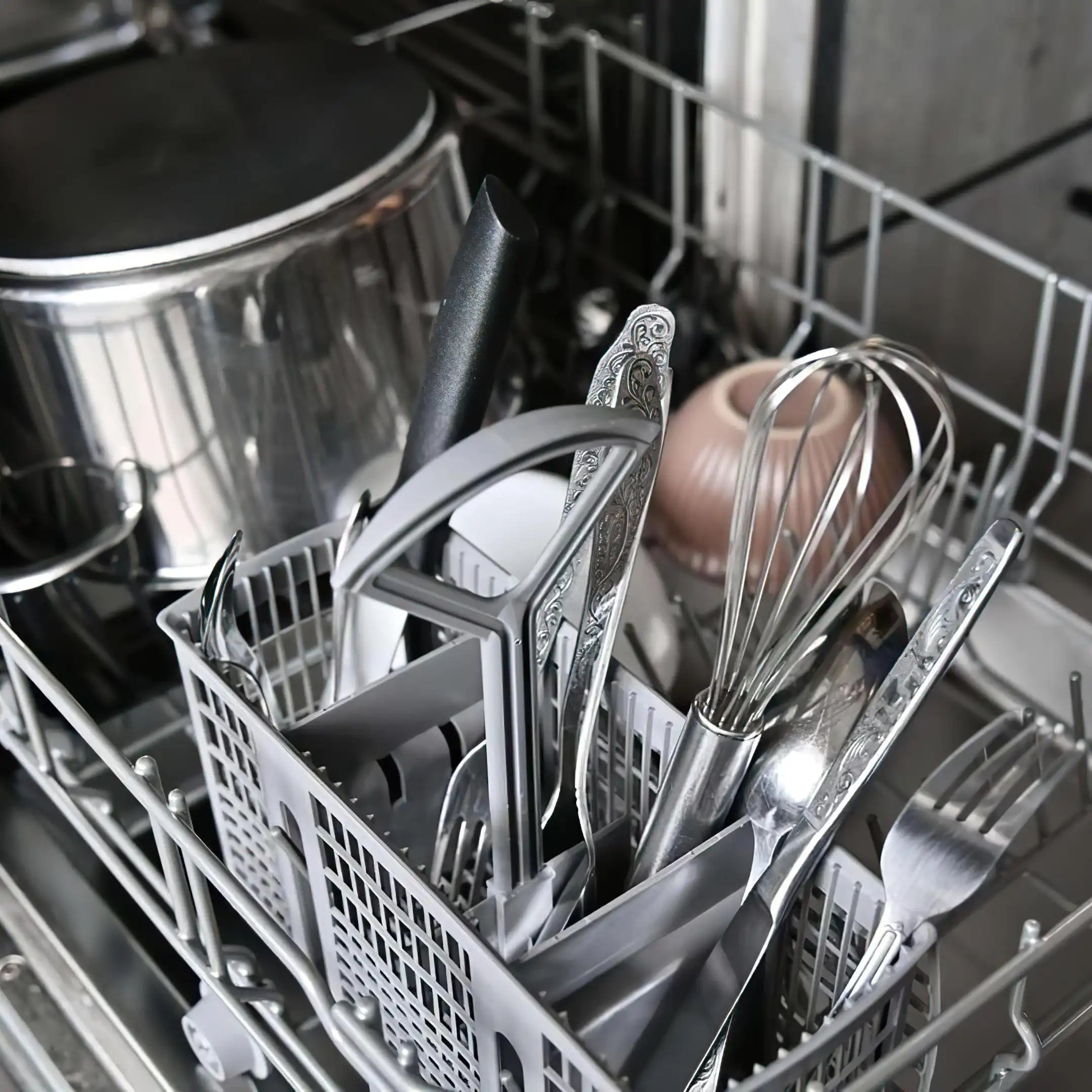 Máquina lavavajillas abierta con platos y cubertería preparados para el lavado en Gran Canaria.