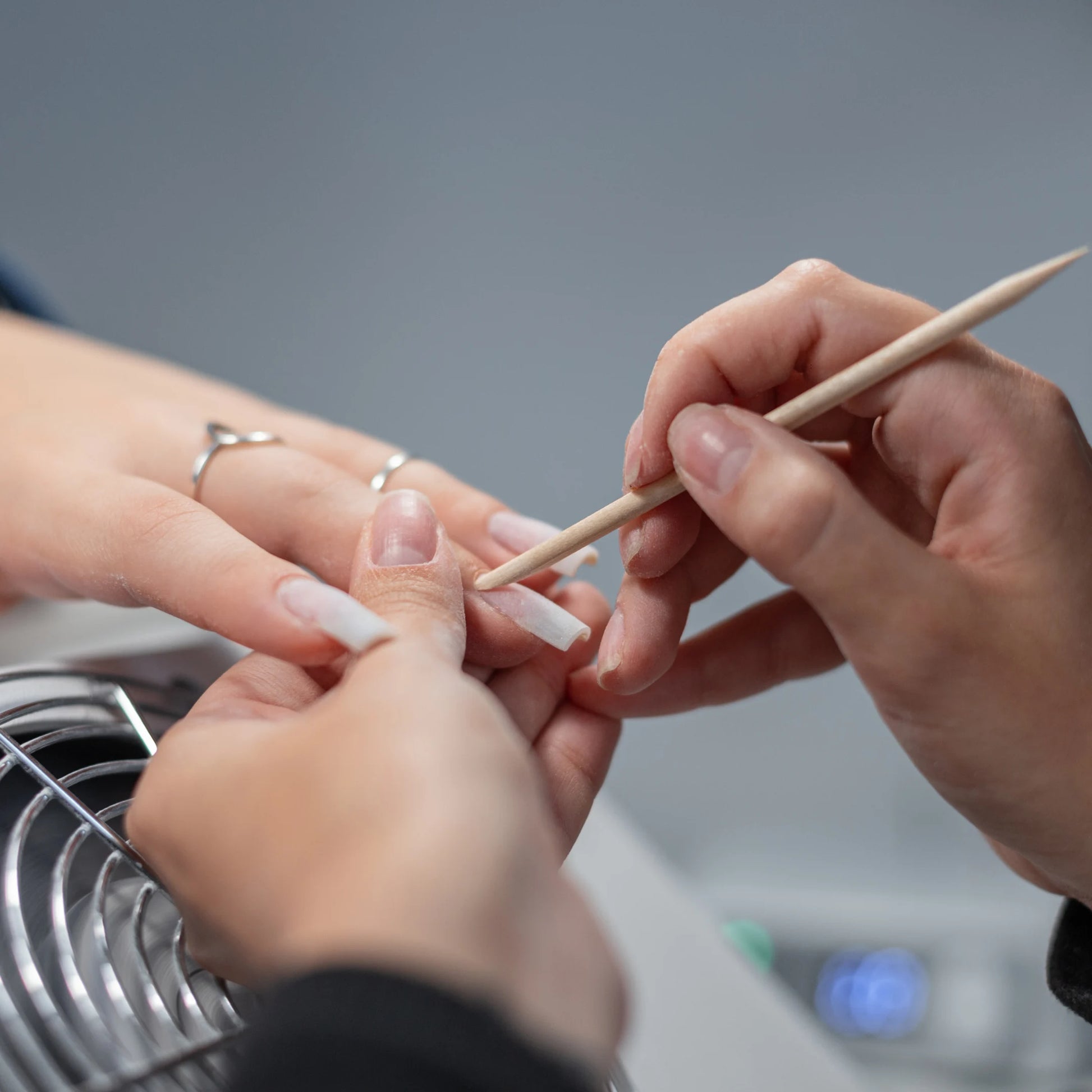 Manicurista trabajando las uñas de una clienta con palitos de naranjo durante un servicio profesional en Gran Canaria