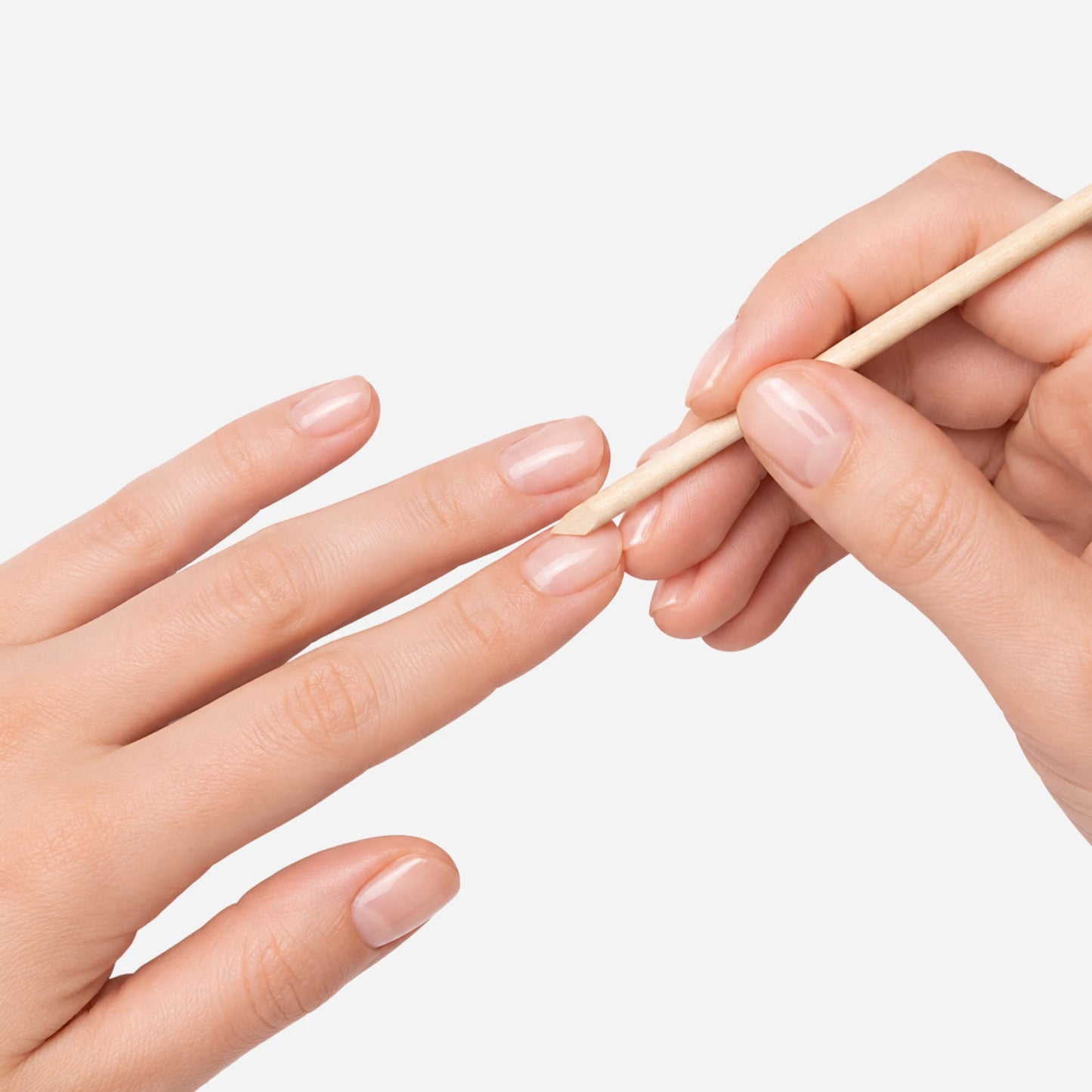 Persona utilizando un palito de naranjo para empujar la cutícula durante el cuidado de sus uñas en Gran Canaria
