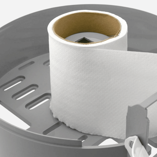 Papel higiénico industrial colocado en portarrollos de baño público.