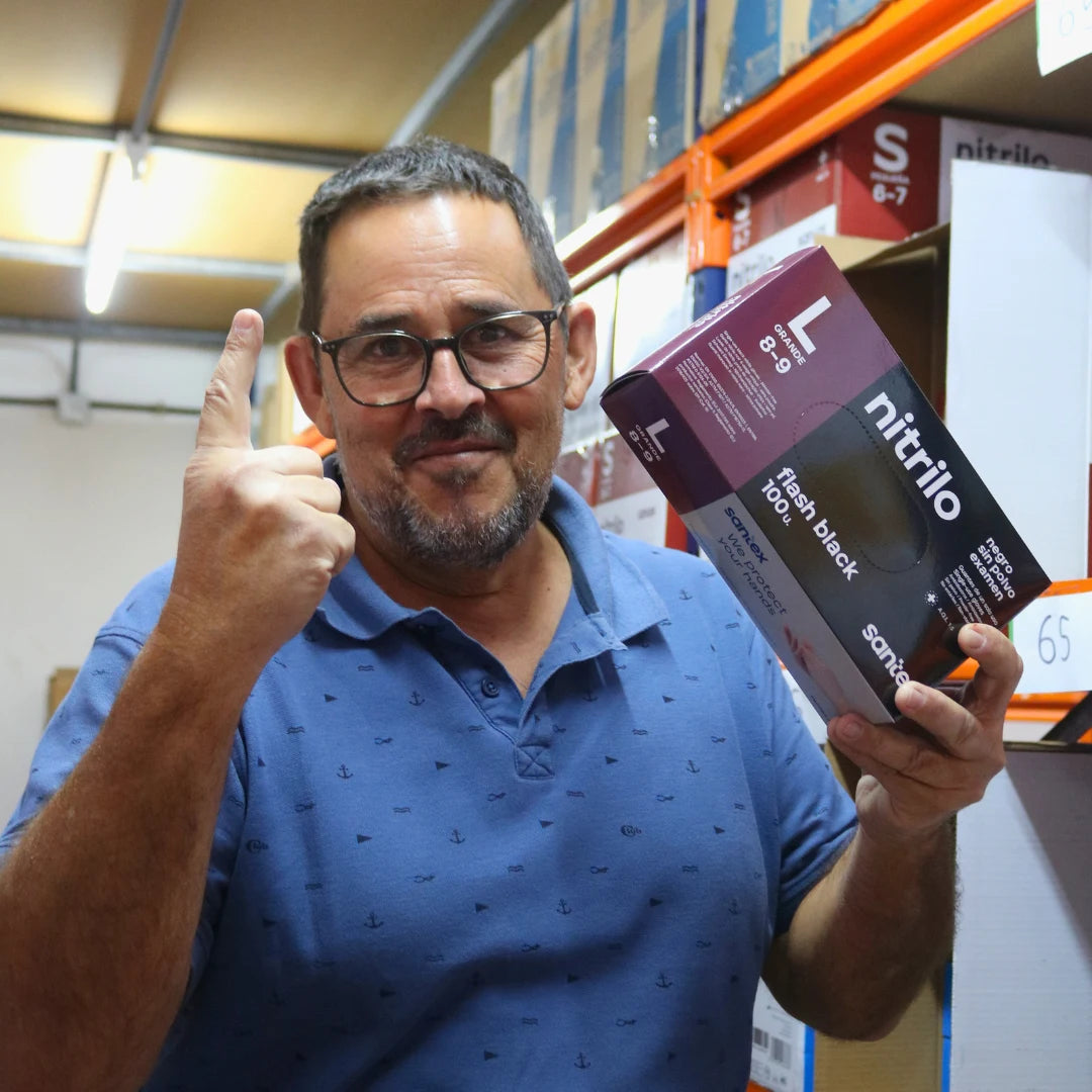 Proveedor de guantes desechables en Gran Canaria sosteniendo un guante de nitrilo de DMP para venta al por mayor y al detalle.