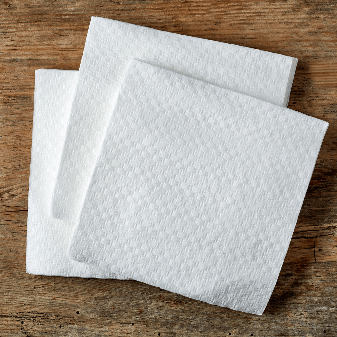 Servilleta de papel 40x40 blanca colocada en mesa de cafetería, acabado con cenefa 1/4 para una presentación elegante en Gran Canaria.