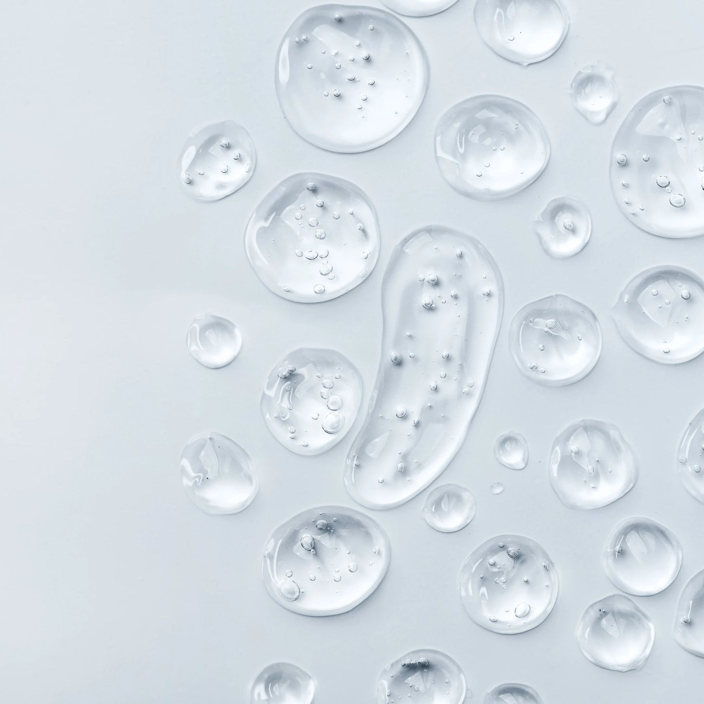 Detalle de gotas transparentes de glicerina vegetal líquida sobre una superficie de cristal