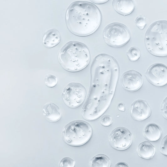 Detalle de gotas transparentes de glicerina vegetal líquida sobre una superficie de cristal